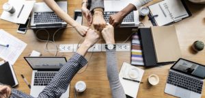 People giving a hand bump at completion of successful meeting.